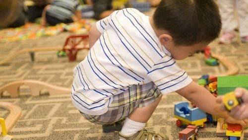 While in a daycare setting, this young boy was entertaining himself by playing with a small wooden toy car set, pushing the little cars along the grooved wooden track. CDC HANDOUT