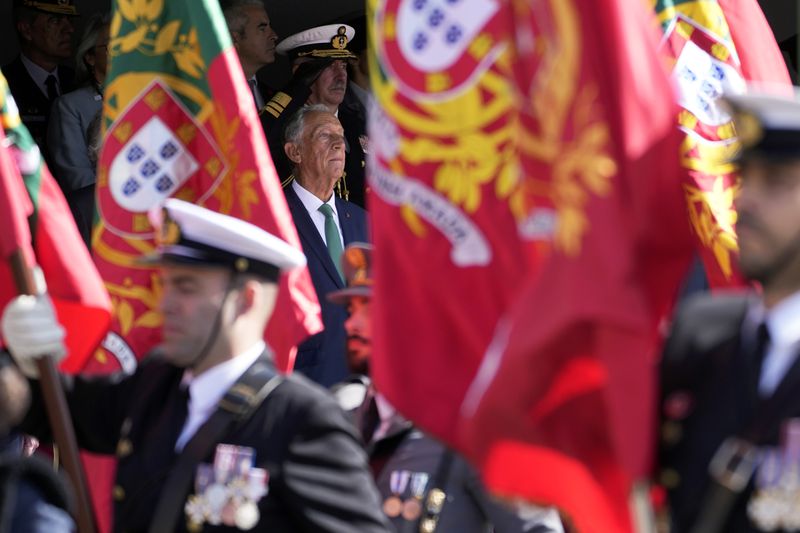 Portuguese President Marcelo Rebelo de Sousa, center, presides over a military parade at Lisbon's Comercio square, Thursday, April 25, 2024, during celebrations of the fiftieth anniversary of the Carnation Revolution. The April 25, 1974 revolution carried out by the army restored democracy in Portugal after 48 years of a fascist dictatorship. (AP Photo/Armando Franca)