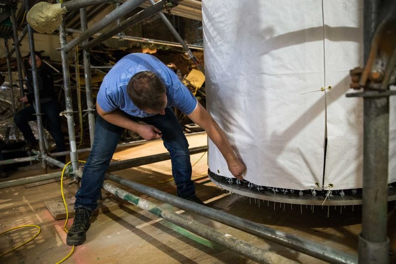 German conservator Ulrich Weilhammer talks about the process of preparing “The Battle of Atlanta” painting to be moved. The painting was separated into two 180-foot sections and rolled onto two of these 45-foot-tall spools. BRANDEN CAMP / SPECIAL