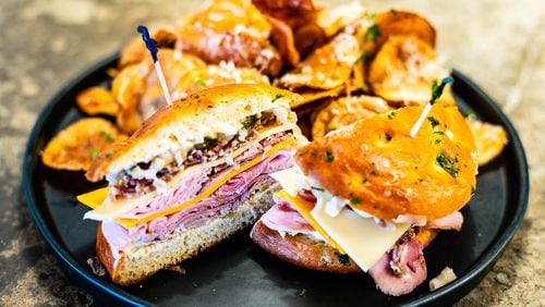 The Butcher the Baker’s muffuletta, served here with truffle-parmesan chips, is essentially a charcuterie board piled onto a sandwich.