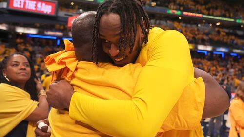 Indiana Pacers center Myles Turner, right, gets a hug after Game 6 against the Milwaukee Bucks in an NBA basketball first-round playoff series, Thursday, May 2, 2024, in Indianapolis. The Pacers won 120-98. (AP Photo/Michael Conroy)