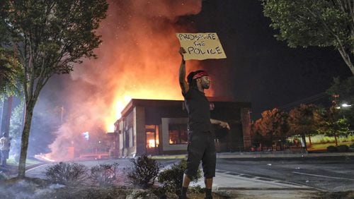 Wendy’s in flames on June 13, 2020, in southwest Atlanta after demonstrators blocked the nearby interstate and set the fast-food eatery on fire. Rayshard Brooks, a 27-year-old Black man, was shot and killed by Atlanta police the previous evening during a struggle in the Wendy’s drive-thru line. (Ben Gray for The Atlanta Journal Constitution)