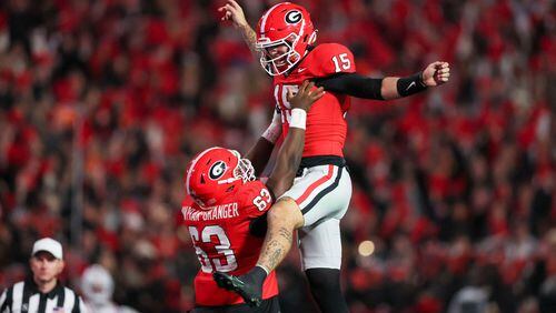 Georgia quarterback Carson Beck (15) celebrates with offensive lineman Sedrick Van Pran (63) after his touchdown pass to wide receiver Ladd McConkey (not pictured) during the first quarter against Ole Miss at Sanford Stadium, Saturday, Nov. 11, 2023, in Athens, Georgia. (Jason Getz/The Atlanta Journal-Constitution/TNS)