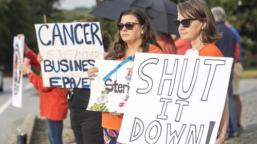 Sherry Corey (right) and Laura Barnes (center) protest against Sterigenics near the Sterigenics plant in Smyrna. (Alyssa Pointer/alyssa.pointer@ajc.com)