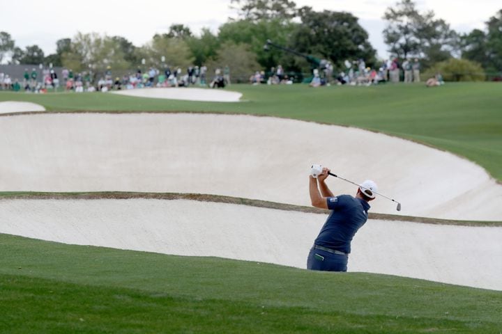 April 9, 2021, Augusta: Dustin Johnson hits out of the bunker on the eighteenth hole during the second round of the Masters at Augusta National Golf Club on Friday, April 9, 2021, in Augusta. Curtis Compton/ccompton@ajc.com