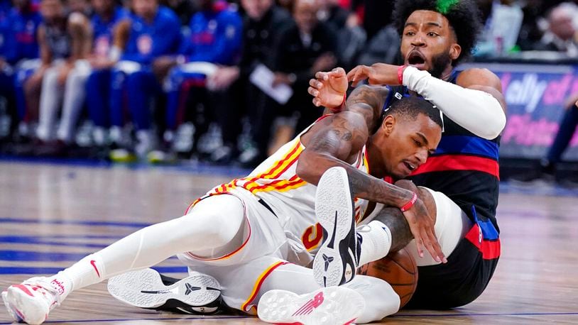 Atlanta Hawks guard Dejounte Murray (5) and Detroit Pistons forward Saddiq Bey (41) get tangled up during the first half of an NBA basketball game, Wednesday, Oct. 26, 2022, in Detroit. (AP Photo/Carlos Osorio)