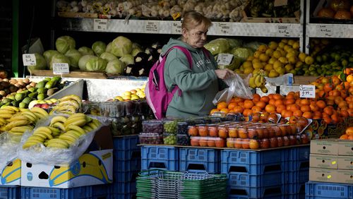FILE - A woman selects fruits at a supermarket in London, on Nov. 17, 2021. Inflation in the U.K. fell to its lowest level in two and a half years in March after a further easing in food prices, official figures showed Wednesday, April 17, 2024. (AP Photo/Frank Augstein, File)