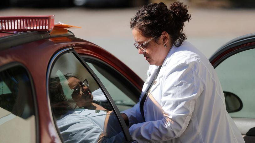 Nurse Practitioner Samantha Soto prepares to give a flu vaccination during a drive through clinic at the St. Joseph's/Candler Good Samaritan Clinic in Garden City.