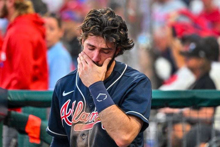 Braves shortstop Dansby Swanson is emotional in the dugout as the Phillies celebrate an 8-3 win that eliminated Atlanta in Game 4 of the NLDS on Saturday at Citizens Bank Park. (Hyosub Shin / Hyosub.Shin@ajc.com)