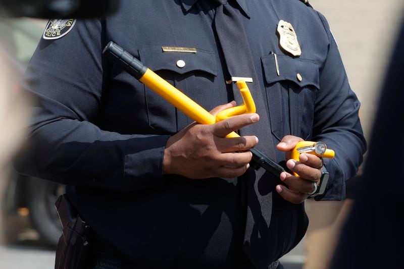 Atlanta Police Major Reginald Moorman holds a steering wheel lock to at Collier Heights Shopping Center in Atlanta on Wednesday, April 5, 2023. Vehicle thefts are on the rise as a result of the viral TikTok challenge in which people are hot wiring Kias and Hyundais with USB cables. (Natrice Miller/natrice.miller@ajc.com)