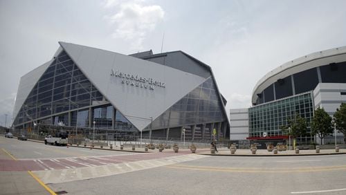 Mercedes-Benz Stadium, left, the new home of the Atlanta Falcons and Atlanta United, is shown next to the Georgia Dome.  (Credit: John Bazemore/Associated Press)