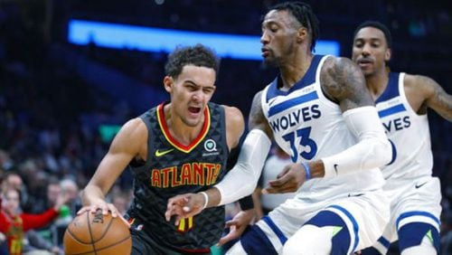 Trae Young of the Hawks drives against Robert Covington of the Timberwolves during Monday's game at State Farm Arena. (AP Photo/Todd Kirkland)