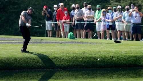 The gallery watches as Phil Mickelson skip his ball across the pond to the sixteenth green during his practice round for the Masters at Augusta National Golf Club on Wednesday, April 7, 2021, in Augusta. Curtis Compton/ccompton@ajc.com