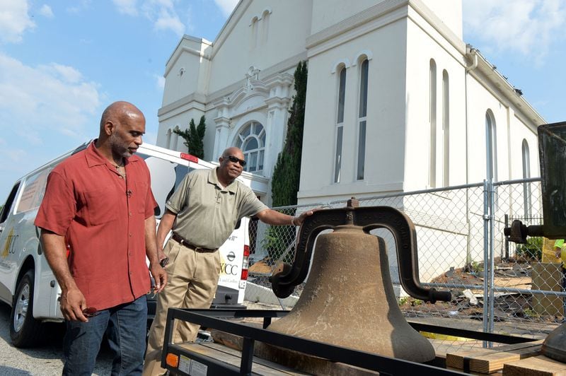 Lloyd Hawk (left), trustee board chairman, and trustee Webster Pope examine the bell before it is taken away from the former building in 2014. The church plans to use the bell in some manner in its new location, Hawk said. KDJOHNSON/KDJOHNSON@AJC.COM