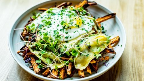 The disco frites at Tin Tin include duck "gravy," brie and a fried duck egg.