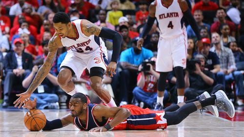 050315 ATLANTA: Wizards John Wall hits the hardwood as Hawks Kent Bazemore defends on the play in game 1 of the Eastern Conference Semifinals on Sunday, May 3, 2015, in Atlanta. Curtis Compton / ccompton@ajc.com