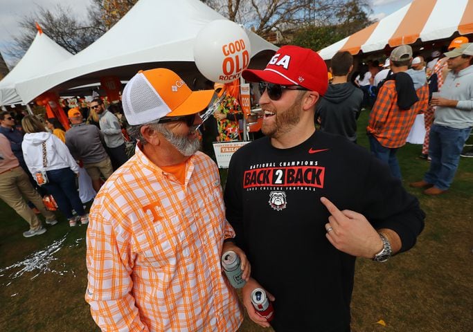 Georgia fan Jake Mathis, Alpharetta, sports his Back-2-Back National Champions shirt while greeting his Tennessee fan friend Chris Tallent, Dalton, arriving for the NCAA college football game on Saturday, Nov. 18, 2023, in Knoxville.  Curtis Compton for the Atlanta Journal Constitution