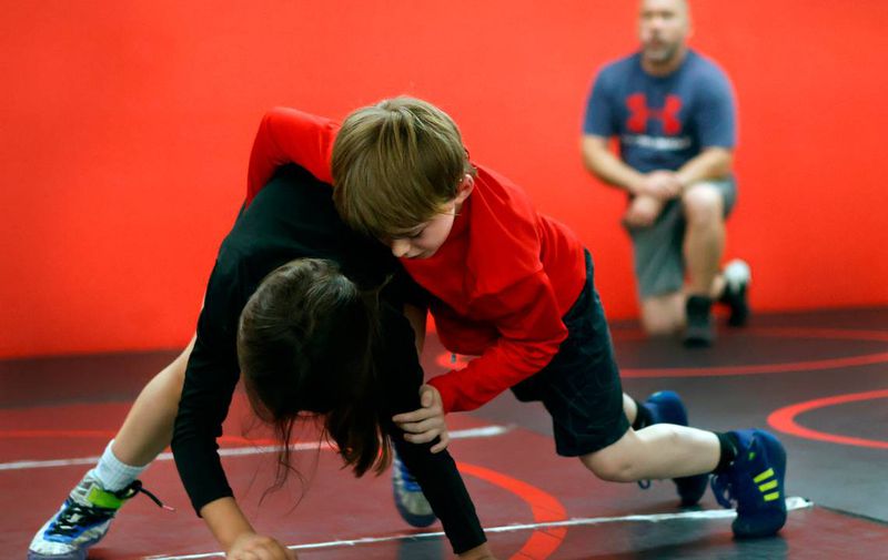 Landon Paris, center, wrestles as his father Carson watches during a recent practice for the Bison Takedown youth wrestling team in Columbus, Georgia. (Photo Courtesy of Mike Haskey)