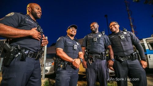 (From left to right) Atlanta police Officers Bill Brooks, Andre Valentine, Elijah McCall and Derek Daniel  helped rescue two people from a fiery crash Wednesday. JOHN SPINK / JSPINK@AJC.COM