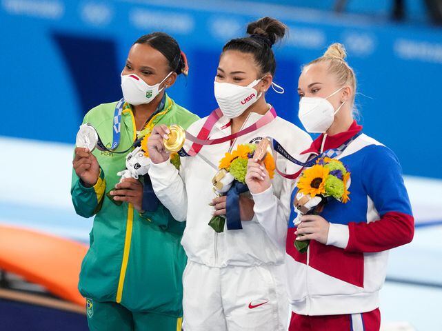Gold medal winner Sunisa Lee of the United States, is flanked by silver medalist Rebeca Andrade of Brazil, left, and bronze medalist Angelina Melnikova of the Russian Olympic Committee during the medal ceremony for.the women's all-around gymnastics competition at the postponed 2020 Tokyo Olympics in Tokyo on Thursday, July 29, 2021. (Chang W. Lee/The New York Times)