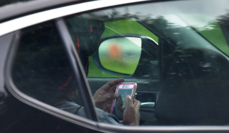 June 21, 2018 Atlanta - A driver apparently uses a  phone while driving in downtown Atlanta on Thursday, June 21, 2018. In one week, police officers across the state will begin enforcing the Hands-Free Georgia Act, which prohibits motorists from holding their phones or other electronic devices while driving. HYOSUB SHIN / HSHIN@AJC.COM