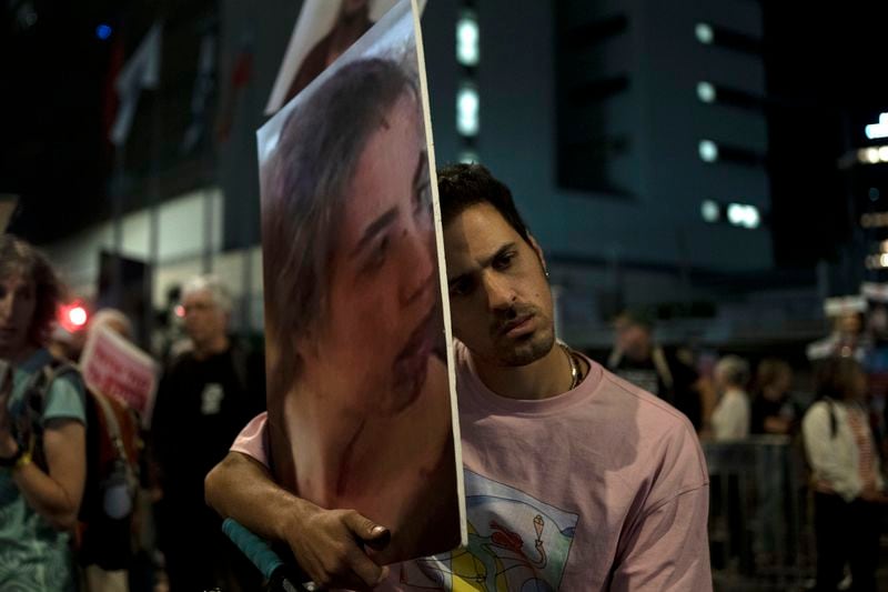 A protester holds a large photo of Agam Berger in Hamas captivity in the Gaza Strip, as families and their supporters march to call on Israeli Prime Minister Benjamin Netanyahu's government to make a deal to free their loved ones, in Tel Aviv, Israel, Wednesday, May 8, 2024. (AP Photo/Maya Alleruzzo)