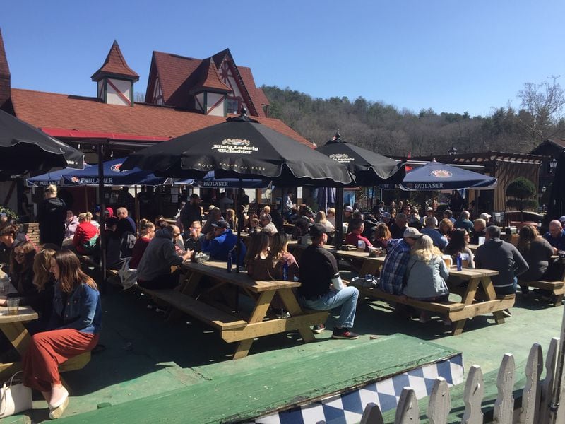 Tourists without masks sit packed together in an outdoor eating area on a sunny day this month in Helen, Ga., a Bavarian-style tourist town in the northeast Georgia mountains. (Johnny Edwards / Johnny.Edwards@ajc.com)