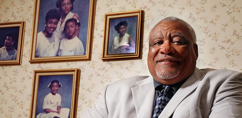 Former Atlanta Falcons star Claude Humphrey poses with his family's portraits in his Bartlett, Tenn. home in 2014.