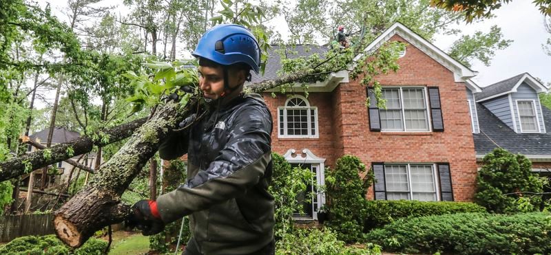 May 3, 2021 Atlanta: Brandon Mazarie of Castor Tree Service brings out sawed limbs as his crew removed a tree from a house on Forest Crossing Drive on Monday, May 3, 2021. A possible tornado tracked on the ground for several miles, starting in Douglas County and moved northeast through the city into northern DeKalb County, according to Channel 2 Action News meteorologists. The National Weather Service will conduct a survey to confirm the tornado and determine its strength. In Atlanta, fire crews responded to a number of calls for trees down on homes and on the streets along the Cascade Road corridor. (John Spink / John.Spink@ajc.com)

