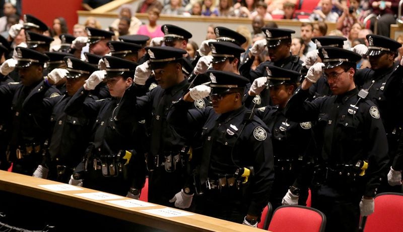 March 18, 2015 Atlanta: Atlanta Police officers prepare to remove their hats in unison during their recruit class graduation ceremony Wednesday evening March 18, 2015 at North Atlanta High School. Ben Gray / bgray@ajc.com