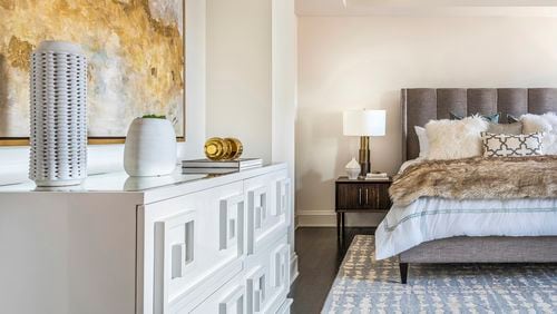 A warm gray upholstered bed helps create a soothing atmosphere. Contributed by Design Recipes
