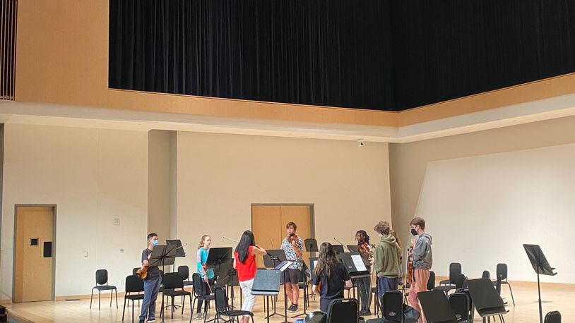 Renowned musician Helen Kim (in red) leads a group of high school students through an intensive strings session at KSU's summer program.