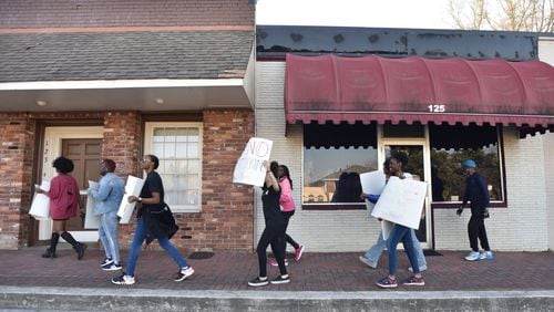 Students holding signs walk through downtown Jonesboro to demonstrate tobacco’s deadly effects on March 20, 2019. Youth use of electronic cigarettes “has reached an epidemic proportion,” the leader of the Food and Drug Administration and the U.S. surgeon general have said recently. HYOSUB SHIN / HSHIN@AJC.COM