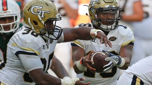Jackets QB TaQuon Marshall fakes a handoff to KirVonte Benson (30) during the first half of Saturday's game. (AP Photo/Wilfredo Lee)