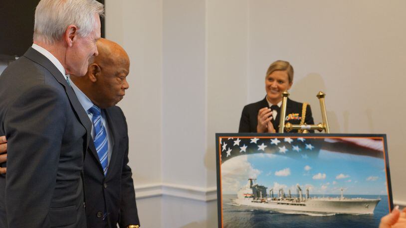 Navy Secretary Ray Mabus embraces U.S. Rep. John Lewis in 2017 as they unveil a rendering of a ship to be named after the Georgia congressman. (Courtesy: Office of John Lewis)