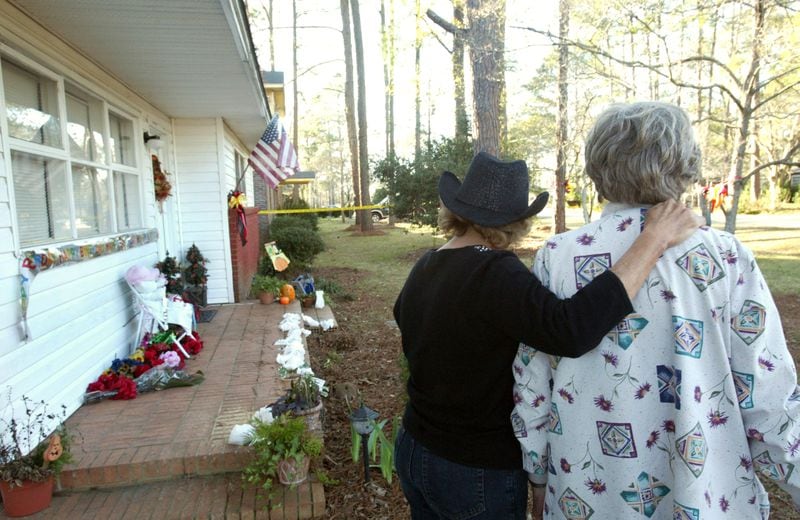 Linda Fletcher (left), who volunteers at the Tara Command Center, and Myrtle Portier, a neighbor of Tara Grinstead, spend a moment in front of the missing schoolteacher's Ocilla home. (JENNI GIRTMAN/AJC staff)