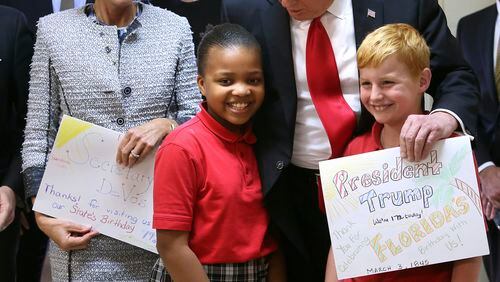 President Donald Trump thanks students at St. Andrew Catholic School in Orlando, Fla., for cards they made him. The trip highlighted Trump’s support for vouchers, which is reflected in the budget proposal he released today. With the president, from left to right, are: Trump son-in-law Jared Kushner; U.S. Secretary of Education Betsy DeVos, and Trump daughter Ivanka Trump. (Joe Burbank/Orlando Sentinel via AP)