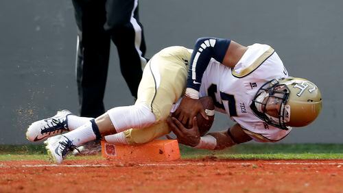 Georgia Tech quarterback Justin Thomas (5) falls into the end zone for a touchdown against North Carolina State during the first half of an NCAA college football game in Raleigh, N.C., Saturday, Nov. 8, 2014. (AP Photo/Gerry Broome)
