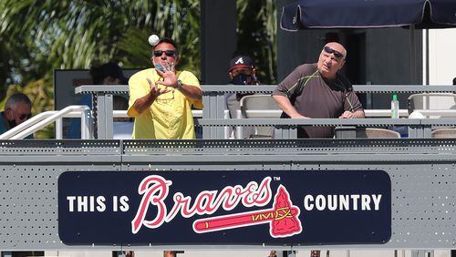 A Braves fan in the Tomahawk Tiki Bar & Grill, located beside left field in CoolToday Park, catches a batted ball during the first full-squad workout Tuesday. (Curtis Compton/Atlanta Journal-Constitution)