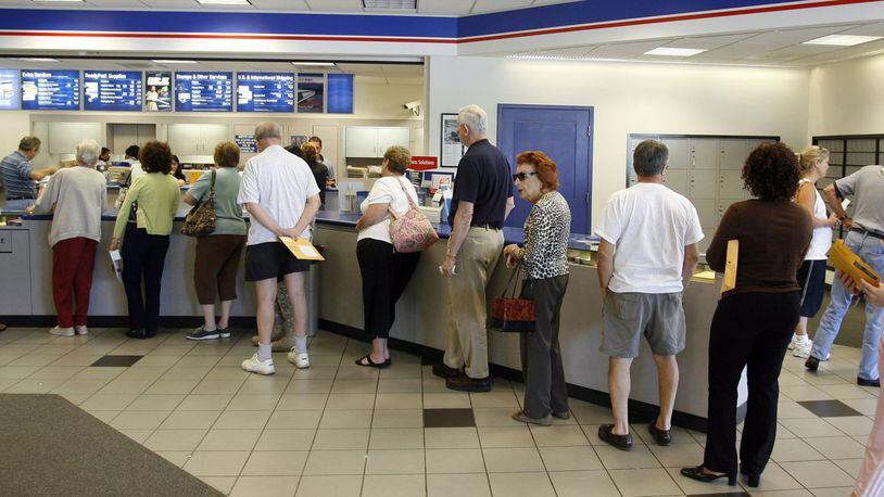 ROSWELL, GA — The first-class mail postage rate increased to 41 cents on July 5, 2014. The stamp machine was sold out of the new stamps and the morning line was long at the Roswell post office on Alpharetta Highway in Roswell. (BOB ANDRES / AJC staff)