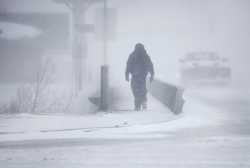 A man crosses over a creek during a blizzard on March 13, in Cheyenne, Wyoming, as a "bomb cyclone" hit the United States.