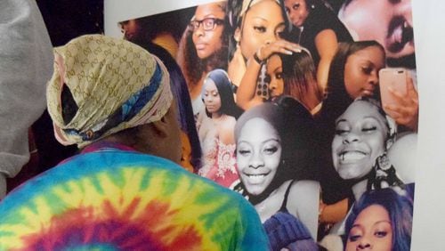Sanmarian McClain looks at photos of her 18-year-old daughter, Jessica, who was killed Thursday.