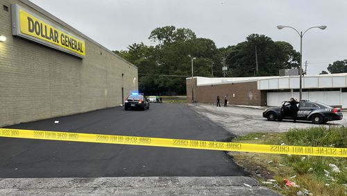 Crime scene tape blocked the parking lot between a Dollar General store and a package store on Wesley Chapel Road while police investigated a shooting Tuesday morning.