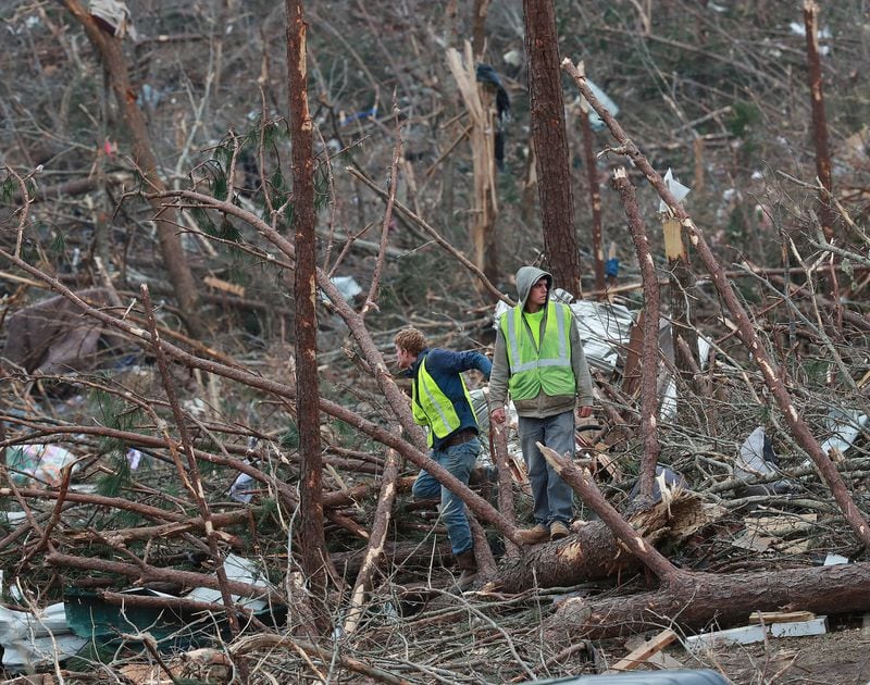 Two men search through the debris along Lee Road 38 after a F-3 tornado on Monday, March 4, 2019, in Beauregard, Alabama. 