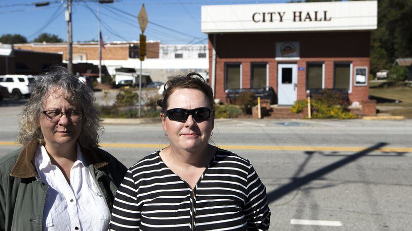 10-24-18 - Statham, GA - Sondra Moore (left), 47, of Hoschton, Ga., and Catherine Corkren, 47, of Atlanta, Ga., pose for a portrait across the road from Statham City Hall in Statham, Ga., on Wednesday, Oct. 24, 2018. Because of open criticism due to what they say is wrongdoing by the city, both Corkren and Moore have been banned from the city of Statham. (Casey Sykes for The Atlanta Journal-Constitution)