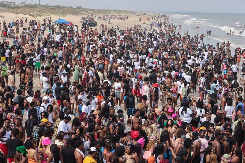 A crowd of partiers gather on the beach for Orange Crush in Tybee Island on Saturday, April 20, 2024. The island put various traffic and safety protocols in place in anticipation of large crowds in town Orange Crush, an annual spring break gathering for college students. (Natrice Miller/ AJC)