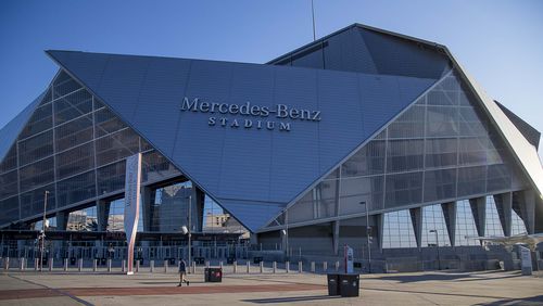 One person walks past Mercedes-Benz Stadium, which would have been the site of the college basketball Final Four this weekend. It was cancelled due to the coronavirus outbreak. (ALYSSA POINTER / ALYSSA.POINTER@AJC.COM)