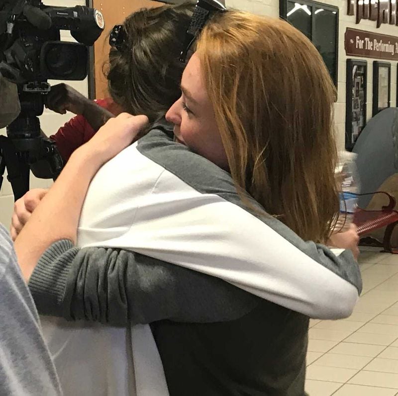 A classmate embraces Brookwood High School senior Megan Hawes, who wrote notes to each member of the class of 2017. ERIC STIRGUS / ESTIRGUS@AJC.COM