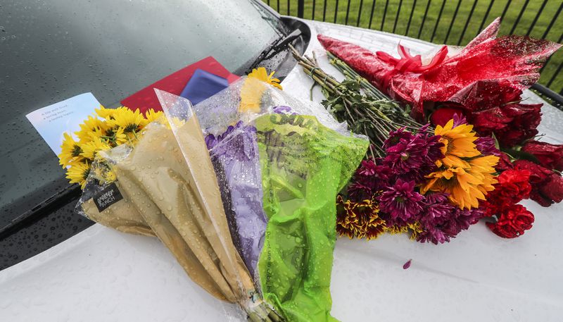 September 12, 2022 Atlanta: A memorial of two patrol cars was parked with flowers and notes served as a reminder of the tragedy last week of two Cobb County deputies killed in the line of duty.  (John Spink / John.Spink@ajc.com)

