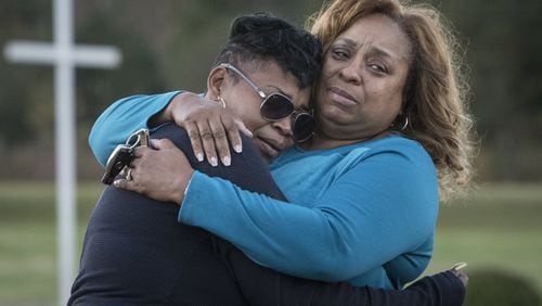 Akiyoshi Metts, left, is comforted by her aunt Carla Butler, at the site of her mother’s grave on her mother’s (Renee Metts) birthday, Monday, Nov.13, 2017 in in Palmetto, Ga. Fulton County is terminating a contract it had for Morehouse School of Medicine to provide medical care for its inmates because, according to a letter, its doctors had failed to provide adequate care. Jail officials attribute at least five inmate deaths to that sub-par care. (Contributed by John Amis) AJC FILE PHOTO
